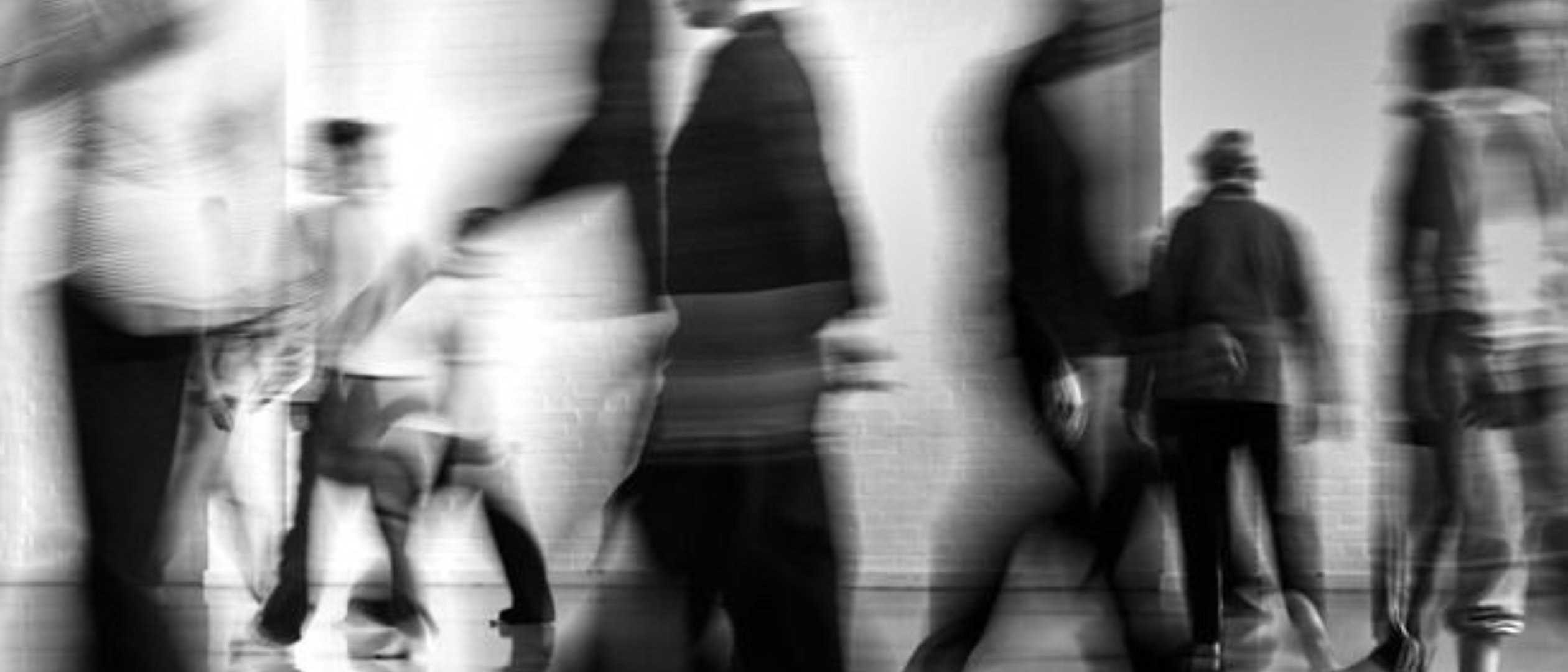 Figures in motion through a bright space, monochrome